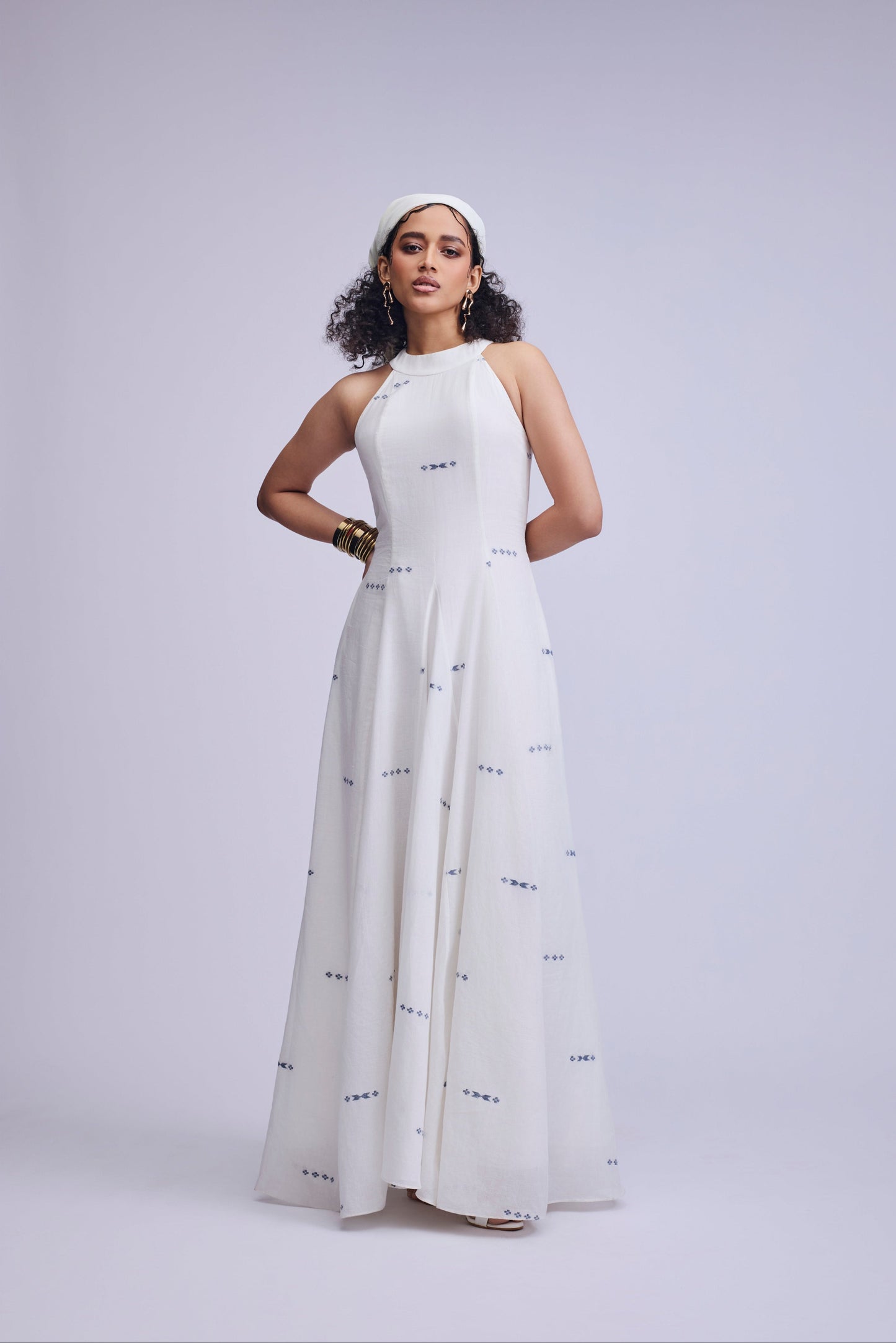 Woman wearing a white dress with black patterns on a light gray background