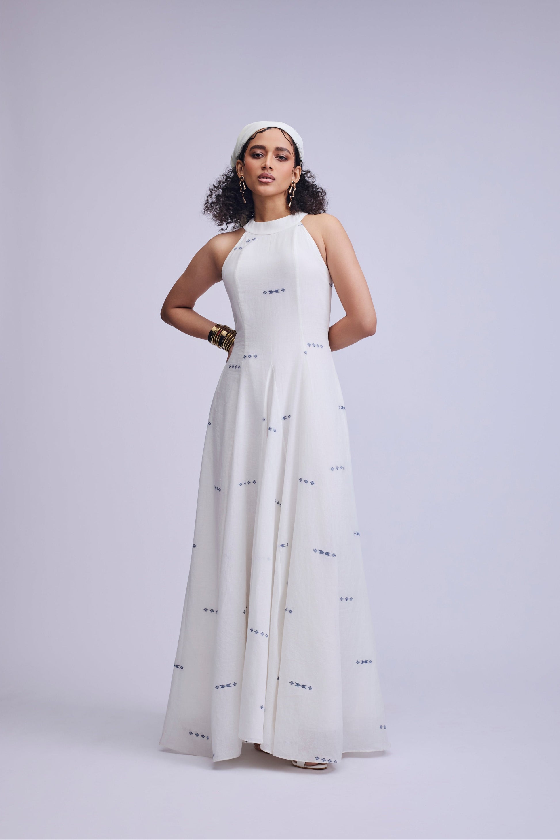 Woman wearing a white dress with black patterns on a light gray background